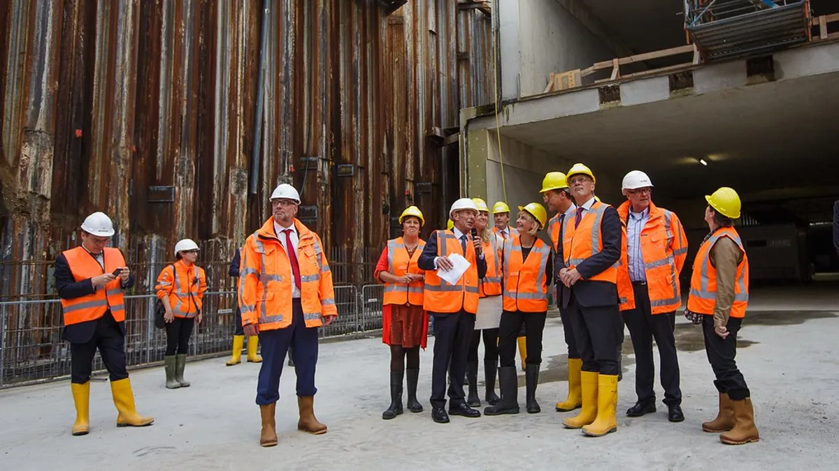 Bouwvakkers in oranje veiligheidskleding op een bouwplaats
