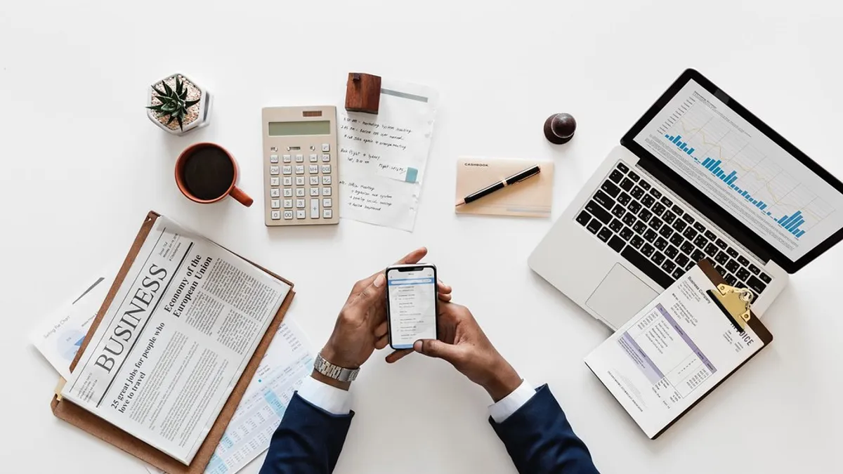 Zakelijk bureau met rekenmachine, laptop en financiële documenten